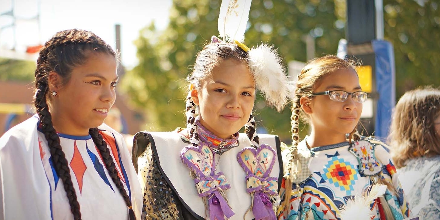 A group of girls dressed in native attire are standing next to each other.